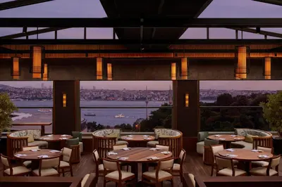 a restaurant with tables and chairs and a view of the water at The Ritz-Carlton, Istanbul at the Bosphorus in Istanbul