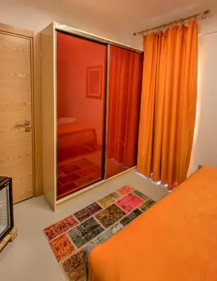 a bedroom with an orange bed and a glass door at Vavien Hotel in Istanbul