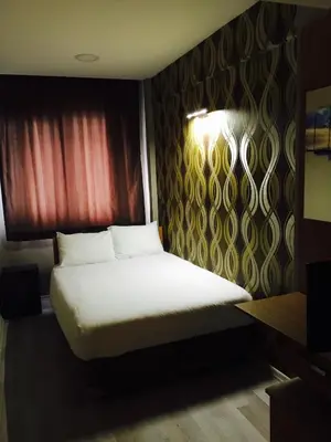 a bedroom with a bed with a white sheets and a window at Okur Otel in Istanbul