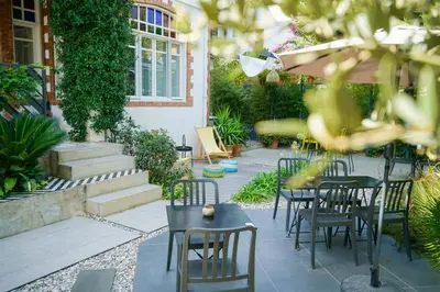 a patio with tables and chairs and plants at Serguzest Otel in Buyukada