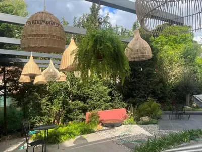 a garden with wicker chairs and tables and plants at Serguzest Otel in Buyukada
