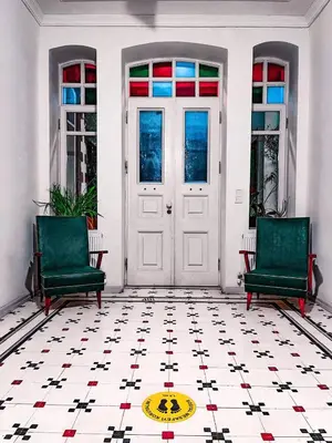 a room with two green chairs and a door at Serguzest Otel in Buyukada