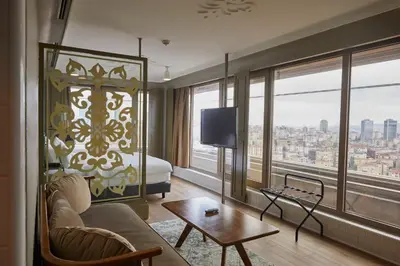 a hotel room with a couch and a bed and window at The Cettia Istanbul in Istanbul