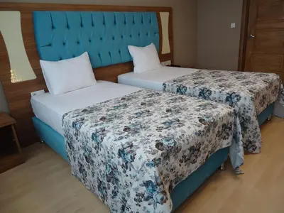 two beds in a hotel room with a blue headboard at Golden Lounge Hotel in Istanbul