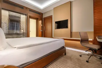 a bedroom with a bed and a desk and a chair at Grand Harilton Otel in Istanbul