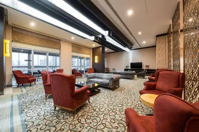 a lobby with a waiting room with chairs and a tv at Clarion Hotel Istanbul Mahmutbey in Istanbul