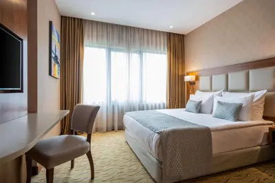 a hotel room with a bed and a desk and a television at Clarion Hotel Istanbul Mahmutbey in Istanbul