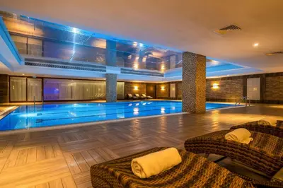 a swimming pool in a hotel with two couches at Clarion Hotel Istanbul Mahmutbey in Istanbul