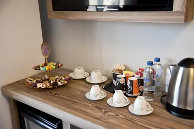 a kitchen counter with cups and saucers on it at Vali Konak Hotel Nişantaşı in Istanbul