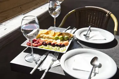 a table with a plate of food and glasses of wine at Vali Konak Hotel Nişantaşı in Istanbul