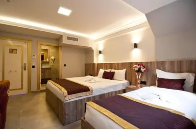 a hotel room with two beds and a bathroom at Vali Konak Hotel Nişantaşı in Istanbul