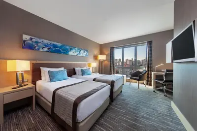 a hotel room with two beds and a desk at Park Dedeman Bostanci Hotel in Istanbul