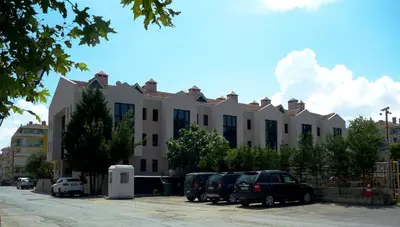 a large building with cars parked in a parking lot at Montania Town Hotel Mudanya in Mudanya