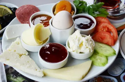 a plate of food with eggs and jam and cheese at Montania Town Hotel Mudanya in Mudanya