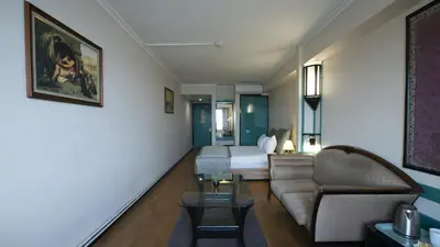 a living room with a couch and a bed in a room at Kadıköy Rıhtım Hotel in Istanbul