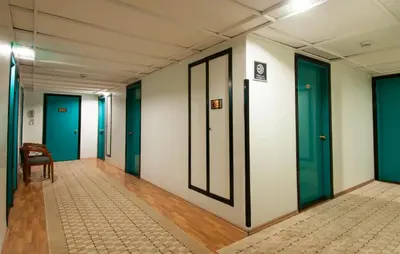 a row of doors in a hallway with a chair at Kadıköy Rıhtım Hotel in Istanbul