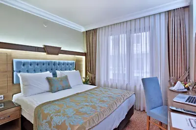 a hotel room with a bed and a desk and a chair at Budo Hotel in Istanbul
