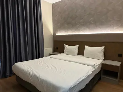 a bedroom with a large bed with white sheets at Niconya Port Suite&Hotel in Istanbul