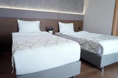 two beds in a hotel room with white sheets at Niconya Port Suite&Hotel in Istanbul