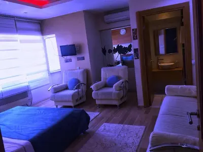 a bedroom with a bed and chairs and a bathroom at Masal Otel in Kocaeli
