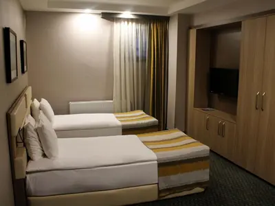 a hotel room with two beds and a television at Tophane Suites in Istanbul