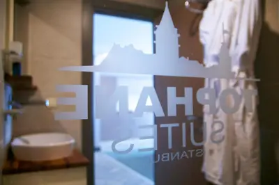 a bathroom with a toilet and a glass door at Tophane Suites in Istanbul