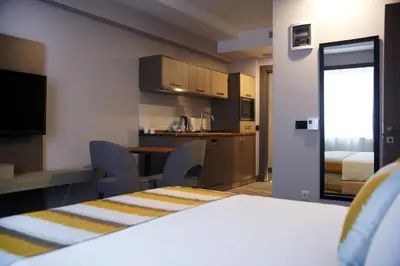 a room with a table and chairs and a kitchen at Tophane Suites in Istanbul
