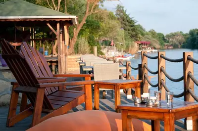 a group of chairs and tables next to a body of water at Agva Nehir Evi - Adult Only in Agva