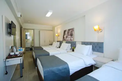 a hotel room with three beds and a desk at Sim Hotel Istanbul Old City in Istanbul