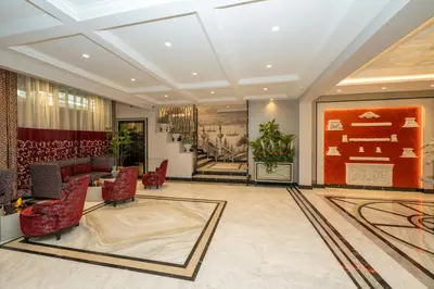 a lobby with red chairs and a staircase at The Byzantium Suites Hotel & Spa in Istanbul