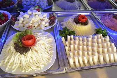 a display case with different types of food on plates at Gumus Palace Suites in Istanbul