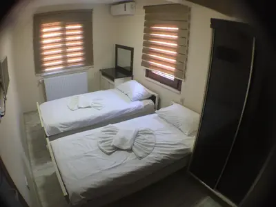 two beds in a room with a mirror and two windows at Beyoglu Huzur Hotel in Istanbul