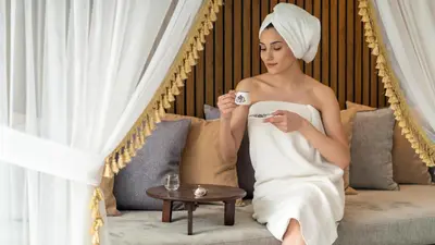 a woman sitting on a couch holding a cup of coffee at Ramada Plaza By Wyndham Sultanahmet in Istanbul