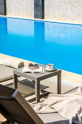 a table and a chair next to a swimming pool at Ramada Plaza By Wyndham Sultanahmet in Istanbul