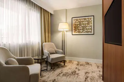 a hotel room with two chairs and a table and a lamp at Ramada Plaza By Wyndham Sultanahmet in Istanbul