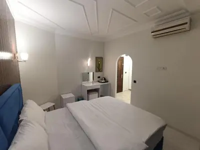 a bedroom with a white bed and a hallway at Villa Sofia in Istanbul