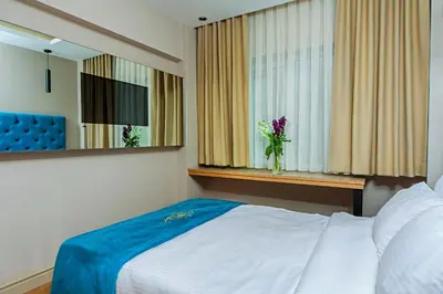 a bedroom with a bed and a window with a vase of flowers at History Hotel in Istanbul