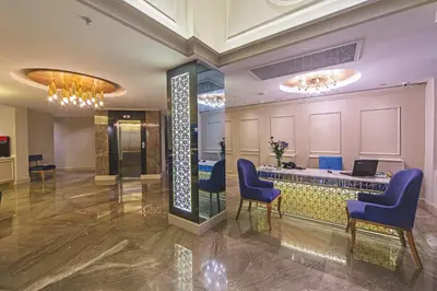 a lobby with a reception desk and blue chairs at History Hotel in Istanbul