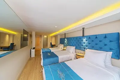 a hotel room with two beds and a blue headboard at History Hotel in Istanbul
