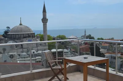 a chair and a table on a balcony with a mosque at Art City Hotel Istanbul in Istanbul