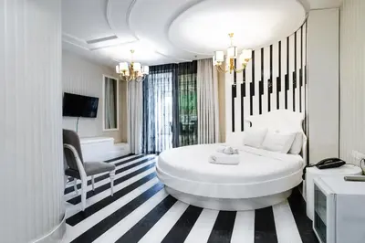 a bedroom with a large white bed and a chair at Golden Pars Hotel in Bursa