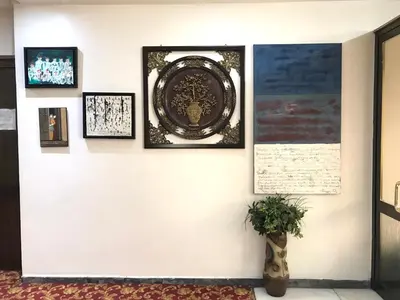 a wall with framed pictures and a poster on it at Hotel Cesmeli in Bursa