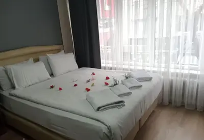 a bed with red roses on it with a window at Hotel Cesmeli in Bursa