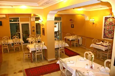 a restaurant with white tables and chairs in a room at Divas Hotel in Istanbul