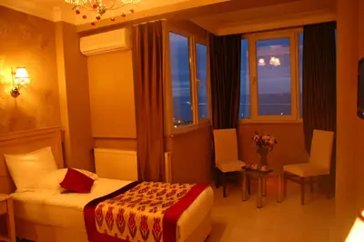 a hotel room with a bed and a chair and windows at Divas Hotel in Istanbul