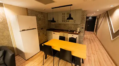 a kitchen with a wooden table and a refrigerator at Mas Suites Nisantasi in Istanbul