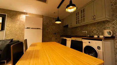 a kitchen with a wooden table and a washer at Mas Suites Nisantasi in Istanbul