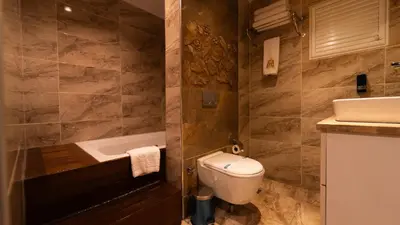 a bathroom with a toilet and a sink and a tub at Mas Suites Nisantasi in Istanbul