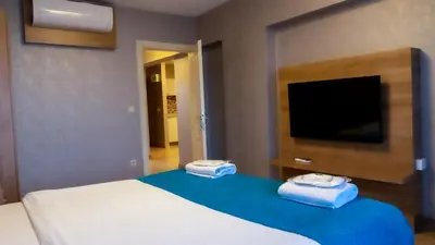a bedroom with a bed and a flat screen tv at Bursa Suites Apart Otel in Bursa