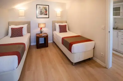 a room with two beds and a table with a lamp at Cheya Sisli BNB Medical & Business City Center Tesvikiye Suites and Apartments in Istanbul